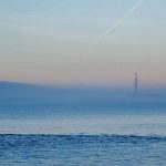 Fawley power station partly obscured by a bank of fog photographed from the Meon Shore at Hill Head