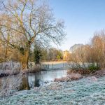 Meon Valley Hampshire The River Meon with St Mary and All Saints Church in the distance.